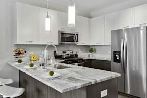 Contemporary kitchen with white cabinetry and stainless appliances at Arden of Oak Brook Apartments, Oakbrook Terrace, Illinois