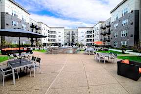 Outdoor courtyard with dining tables and fire feature at Arden of Oak Brook Apartments, Oakbrook Terrace, Illinois