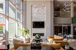 Two story lobby with fireplace and modern seating at Arden of Oak Brook Apartments, Illinois