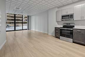 A kitchen with a microwave, oven, and cabinets.
