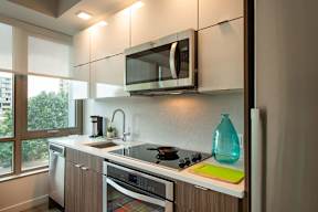 Kitchen with wooden cabinets, black and white appliances1 at Artline Apartments, Washington-DC, 20024