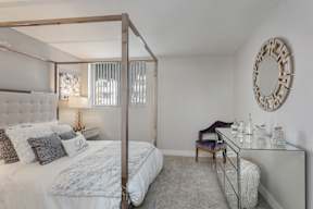 a bedroom with a large bed and a desk with a mirror