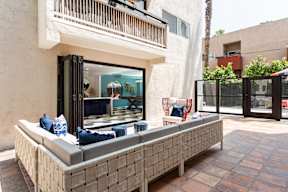 a patio with a seating area and a balcony