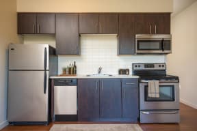 a kitchen with dark cabinets and stainless steel appliances