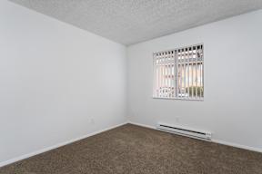 an empty room with white walls and a window