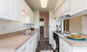 a kitchen with white cabinets and a stove and a sink