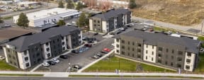an aerial view of an apartment complex with cars parked in a parking lot