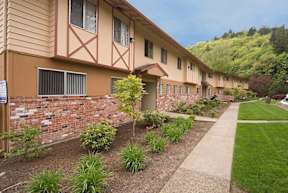 a row of apartments with a sidewalk and landscaping