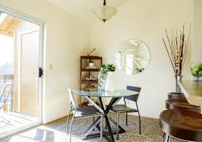 A dining room with a glass table and chairs.