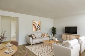 a living room with white furniture and a tv