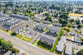 A bird's eye view of a residential area with multiple houses and parked cars.
