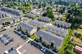 A bird's eye view of a residential area with multiple houses and a parking lot.