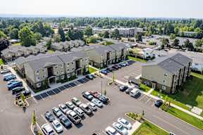A parking lot with cars and apartment buildings in the background.