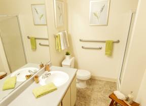 A bathroom with a toilet, sink, and mirror.