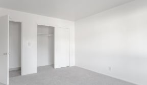 an empty room with white walls and a closet