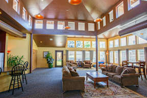 A living room with a brown couch and a wooden table.