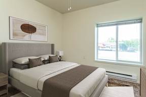 A bedroom with a large bed and a painting on the wall.