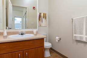 A bathroom with a toilet, sink, and a towel rack.