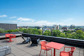 a terrace with tables and chairs and a view of the city