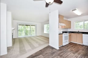 A kitchen with white cabinets and a striped rug on the floor.