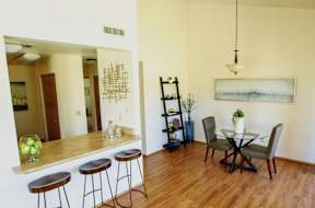 A kitchen with a bar and a dining table.