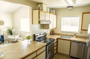 A kitchen with a stove top oven, microwave, and sink.