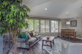 a living room with a couch and a table and a tree