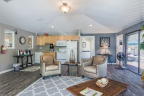 a living room with two chairs and a table and a kitchen