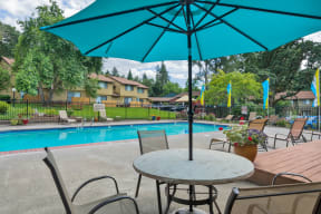 our apartments have a swimming pool and a patio with a table and chairs