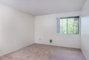 the living room of an empty apartment with a window