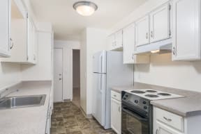 a kitchen with white cabinets and a stove and refrigerator