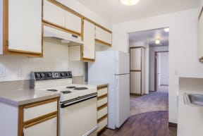 a kitchen with white appliances and wooden cabinets and a white refrigerator