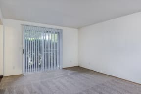 the living room of an apartment with a door to a patio