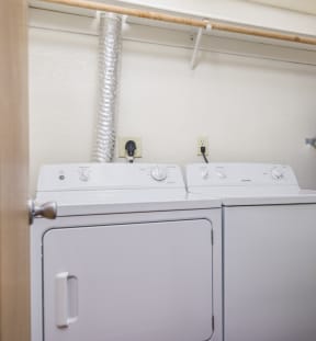 a white washer and dryer in a room with a door