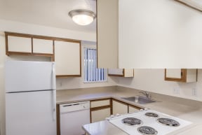 an empty kitchen with a stove and a refrigerator