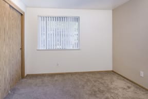 an empty room with a window and a carpet