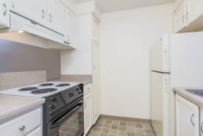 a kitchen with white cabinets and a stove and a refrigerator