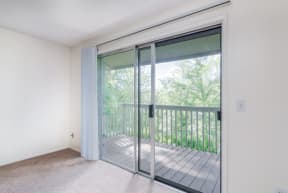 an empty living room with sliding glass doors to a balcony
