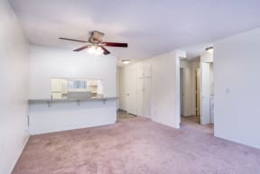 a living room with carpet and a ceiling fan