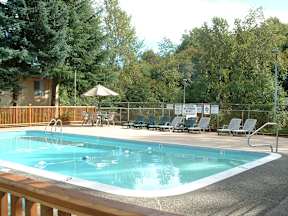 a resort style pool with chairs and an umbrella