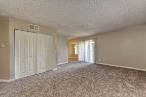 A room with a carpeted floor and a door on the left side.