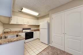 A kitchen with white cabinets and appliances.