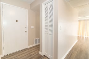 A white door with a brown knob is in a room with a white wall and a white radiator.