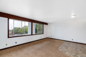 a living room with white walls and a large window