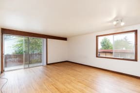 an empty living room with wood floors and a sliding glass door