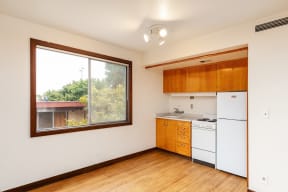an empty kitchen with a large window and white appliances