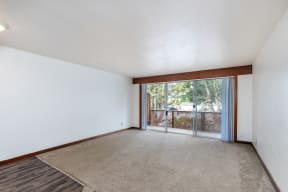 an empty living room with a sliding glass door to a patio