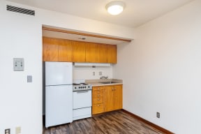 a kitchen with a white stove and refrigerator and wooden cabinets