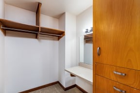 a walk in closet with a mirror and a dresser
