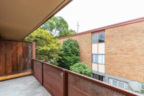 a balcony with a wooden fence and a brick building